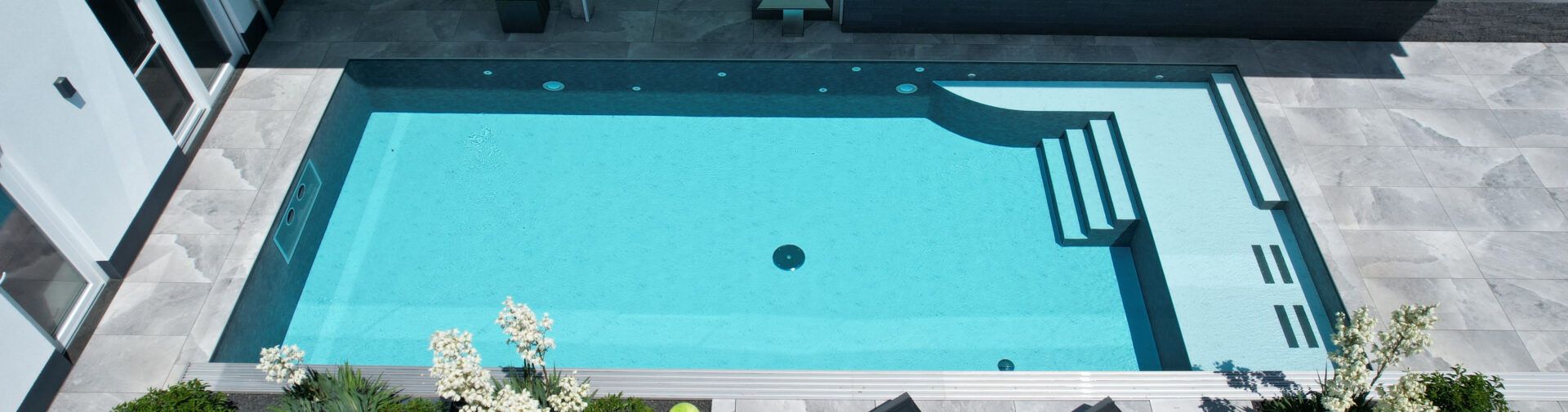 Moderner rechteckiger Pool mit Treppe und Terrasse