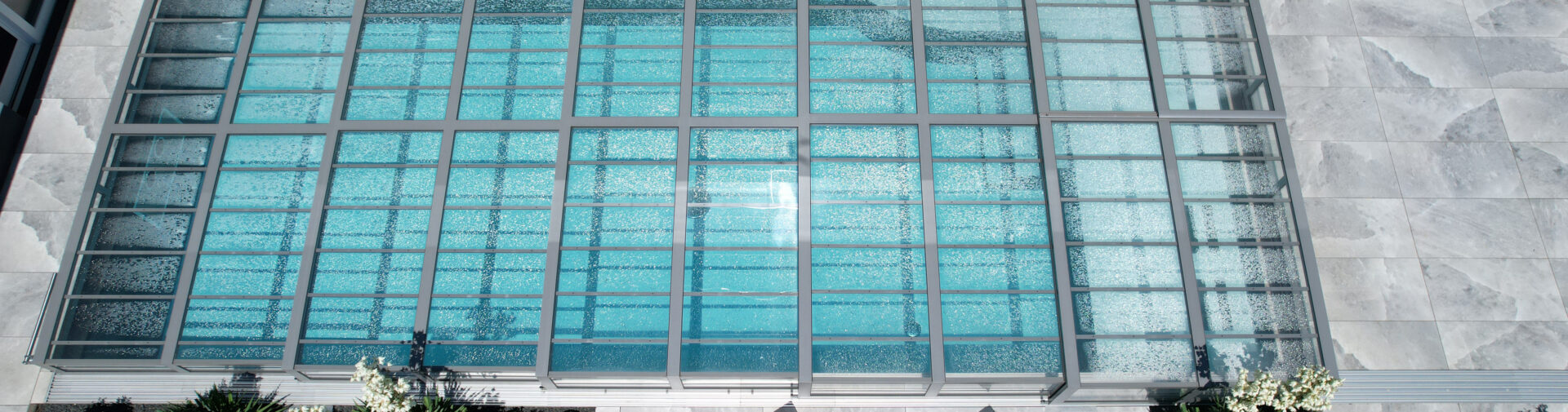 Modernes Schwimmbecken mit Glasdach von oben