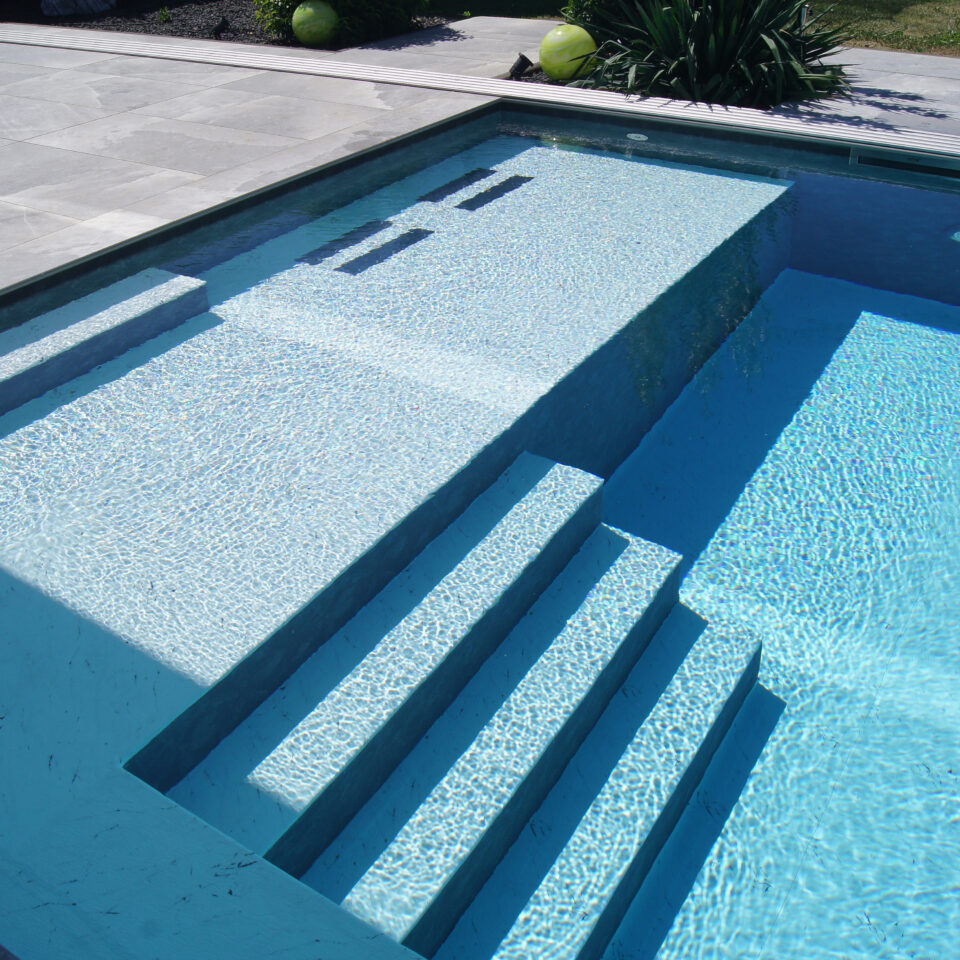Moderne Pooltreppe im klaren blauen Wasser